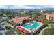 Aerial shot of a community pool area with cabanas, a clubhouse, and mature landscaping at 2709 Via Cipriani # 532B, Clearwater, FL 33764
