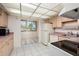 Charming kitchen with appliances, pink countertops, white tile flooring, and a dining area at 4715 Bay Ne St # 323, St Petersburg, FL 33703
