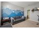 Comfortable living room showcasing unique mountain wall art, a gray sofa, and a view into the adjacent bathroom at 7221 Nightshade Dr, Riverview, FL 33578