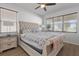 Main bedroom features a tufted headboard, two windows, bedside tables, and views of the neighborhood pond at 7221 Nightshade Dr, Riverview, FL 33578