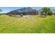 Lush green backyard with a screened-in pool, perfect for outdoor enjoyment and relaxation at 736 Flamingo Dr, Apollo Beach, FL 33572