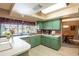 Bright kitchen featuring green cabinets, light countertops, and a breakfast bar at 736 Flamingo Dr, Apollo Beach, FL 33572
