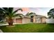 Charming single Gathering home with a well-manicured lawn, lush landscaping, and a beautiful palm tree in the front yard at 895 Sea Holly Dr, Brooksville, FL 34604