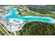A stunning aerial view of a resort-style community with a large lagoon, beach area, and modern amenities at 9119 Forge Breeze Loop, Wesley Chapel, FL 33545
