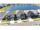 Aerial view of homes in a neighborhood alongside a picturesque lake at 9119 Forge Breeze Loop, Wesley Chapel, FL 33545
