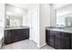 A spacious bathroom featuring double vanities with granite countertops, modern fixtures, and elegant decor, providing comfort and luxury at 9119 Forge Breeze Loop, Wesley Chapel, FL 33545