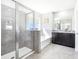 Bright bathroom featuring a glass enclosed shower, garden tub and granite vanity at 9119 Forge Breeze Loop, Wesley Chapel, FL 33545