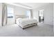Bright bedroom with tray ceiling, carpet, and ensuite bathroom entrance at 9119 Forge Breeze Loop, Wesley Chapel, FL 33545