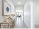 A bright hallway with tile flooring, decorative accents, and an open view into the living area at 9119 Forge Breeze Loop, Wesley Chapel, FL 33545