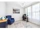 Inviting home office with a blue armchair, stylish desk, and elegant decor, creating a comfortable workspace at 9119 Forge Breeze Loop, Wesley Chapel, FL 33545