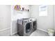Convenient laundry room with modern washer and dryer, plus extra shelving at 9119 Forge Breeze Loop, Wesley Chapel, FL 33545