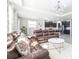 Spacious living room open to kitchen, featuring tile flooring, recessed lights, and a leather sofa at 9119 Forge Breeze Loop, Wesley Chapel, FL 33545