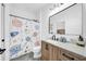 Modern bathroom with cute outer space shower curtain and light wood vanity at 9515 Silverthorn Rd, Seminole, FL 33777