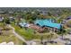Aerial view of the community clubhouse with a pool, patio, golf course, and parking area on a sunny day at 9515 Silverthorn Rd, Seminole, FL 33777