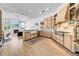 Bright kitchen with wooden cabinetry, stainless steel appliances, farmhouse sink and open to living room at 9515 Silverthorn Rd, Seminole, FL 33777