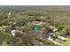 Aerial view of the home surrounded by lush green trees within the surrounding neighborhood at 10113 Huntley St, New Port Richey, FL 34654