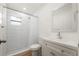 Well lit bathroom featuring a white vanity, a large mirror, and a shower with white subway tiles at 10113 Huntley St, New Port Richey, FL 34654