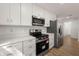 Contemporary kitchen featuring stainless appliances, stylish white cabinetry, and quartz countertops at 10113 Huntley St, New Port Richey, FL 34654