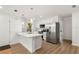 Modern kitchen with stainless steel appliances, white cabinets, and a quartz countertop island at 10113 Huntley St, New Port Richey, FL 34654
