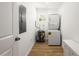 Bright laundry room with a stacked washer and dryer, a water heater, and luxury vinyl plank flooring at 10113 Huntley St, New Port Richey, FL 34654