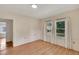 Bedroom features light wood-look floors and two windows with white curtains allowing natural light at 11718 N Ola Ave, Tampa, FL 33612