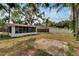 Backyard exterior view of an enclosed patio and surrounding landscape at 11718 N Ola Ave, Tampa, FL 33612