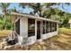 Exterior view of enclosed patio, showcasing its screened windows and tiled roof at 11718 N Ola Ave, Tampa, FL 33612
