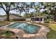 Inviting backyard pool area surrounded by a paved patio and lush landscaping at 11718 N Ola Ave, Tampa, FL 33612