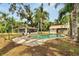 Landscaped backyard area featuring a pool, patio and sunroom at 11718 N Ola Ave, Tampa, FL 33612
