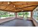 Enclosed sunroom featuring a wood-beam ceiling and concrete floors at 11718 N Ola Ave, Tampa, FL 33612