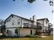 Two-story home with a deck and patio featuring mature trees and green landscaping at 130 80Th Ne Ave, St Petersburg, FL 33702