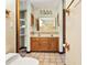 Bathroom featuring a double vanity, tiled floor, and a separate toilet area at 130 80Th Ne Ave, St Petersburg, FL 33702