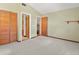 Bright bedroom features neutral carpeting, olive walls, and a closet with louvered doors at 130 80Th Ne Ave, St Petersburg, FL 33702