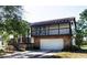 Two-story home showcasing a stone-clad garage, upper-level balcony, and charming curb appeal at 130 80Th Ne Ave, St Petersburg, FL 33702