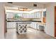 Bright kitchen features white cabinets, black countertops, and stainless-steel appliances at 130 80Th Ne Ave, St Petersburg, FL 33702