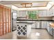 Stylish kitchen with white cabinets, black counters, stainless appliances, and tile flooring at 130 80Th Ne Ave, St Petersburg, FL 33702