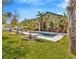 The backyard features a pristine pool, surrounded by lush landscaping, an outdoor kitchen, and comfortable lounge furniture at 1307 Garden Stone Ln, Brandon, FL 33510