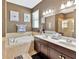 Bathroom with double sinks, dark cabinets, granite counters, soaking tub and a separate glass-enclosed shower at 1307 Garden Stone Ln, Brandon, FL 33510