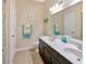 Bright bathroom features double vanity, framed mirror, and beach-themed decor for a relaxing, coastal atmosphere at 1307 Garden Stone Ln, Brandon, FL 33510