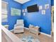 Cozy reading nook with a comfortable armchair, ship artwork, and a blue accent wall, perfect for relaxation at 1307 Garden Stone Ln, Brandon, FL 33510