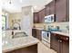 A kitchen showcasing granite countertops, stainless steel appliances and dark wood cabinets provides a practical, gourmet feel at 1307 Garden Stone Ln, Brandon, FL 33510