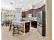 Well lit kitchen with stainless appliances, wooden cabinets, stone countertops, and a breakfast bar at 1307 Garden Stone Ln, Brandon, FL 33510