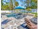 Outdoor living area with in-ground swimming pool, patio furniture, and tropical plants at 1307 Garden Stone Ln, Brandon, FL 33510