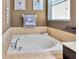 Cozy tub with tile surround in bathroom with decorative artwork and hardware at 1307 Garden Stone Ln, Brandon, FL 33510