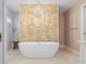 Spa-like bathroom with soaking tub, stone accent wall, and modern fixtures at 1426 75Th Ne Cir, St Petersburg, FL 33702