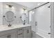 Modern bathroom featuring double sinks, sleek fixtures, and a shower-tub combo with glass door at 1426 75Th Ne Cir, St Petersburg, FL 33702