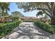 Inviting home exterior featuring a brick driveway, manicured hedges, and a well-maintained lawn at 1426 75Th Ne Cir, St Petersburg, FL 33702