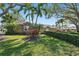 Charming front yard with lush green lawn, mature landscaping, and stone accents on the home's facade at 1426 75Th Ne Cir, St Petersburg, FL 33702