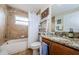 Bathroom with granite countertops, decorative ladder shelf, and tiled shower at 1526 River Ct, Tarpon Springs, FL 34689