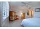 Well lit bedroom with terrazzo floors, custom storage, shuttered windows, and ceiling fan at 1609 Bunker Hill Dr, Sun City Center, FL 33573